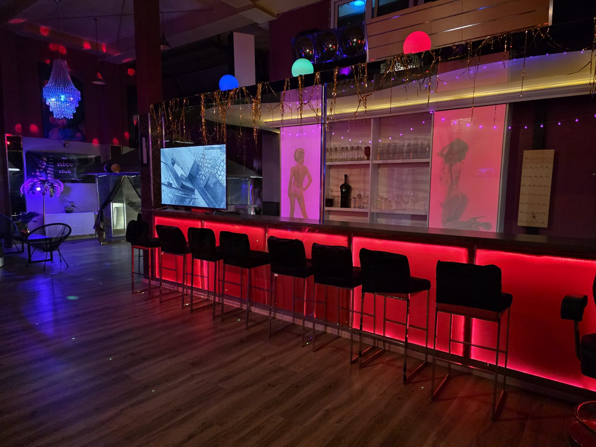 Beleuchteter Barbereich des Royal Love Club mit Sitzplätzen