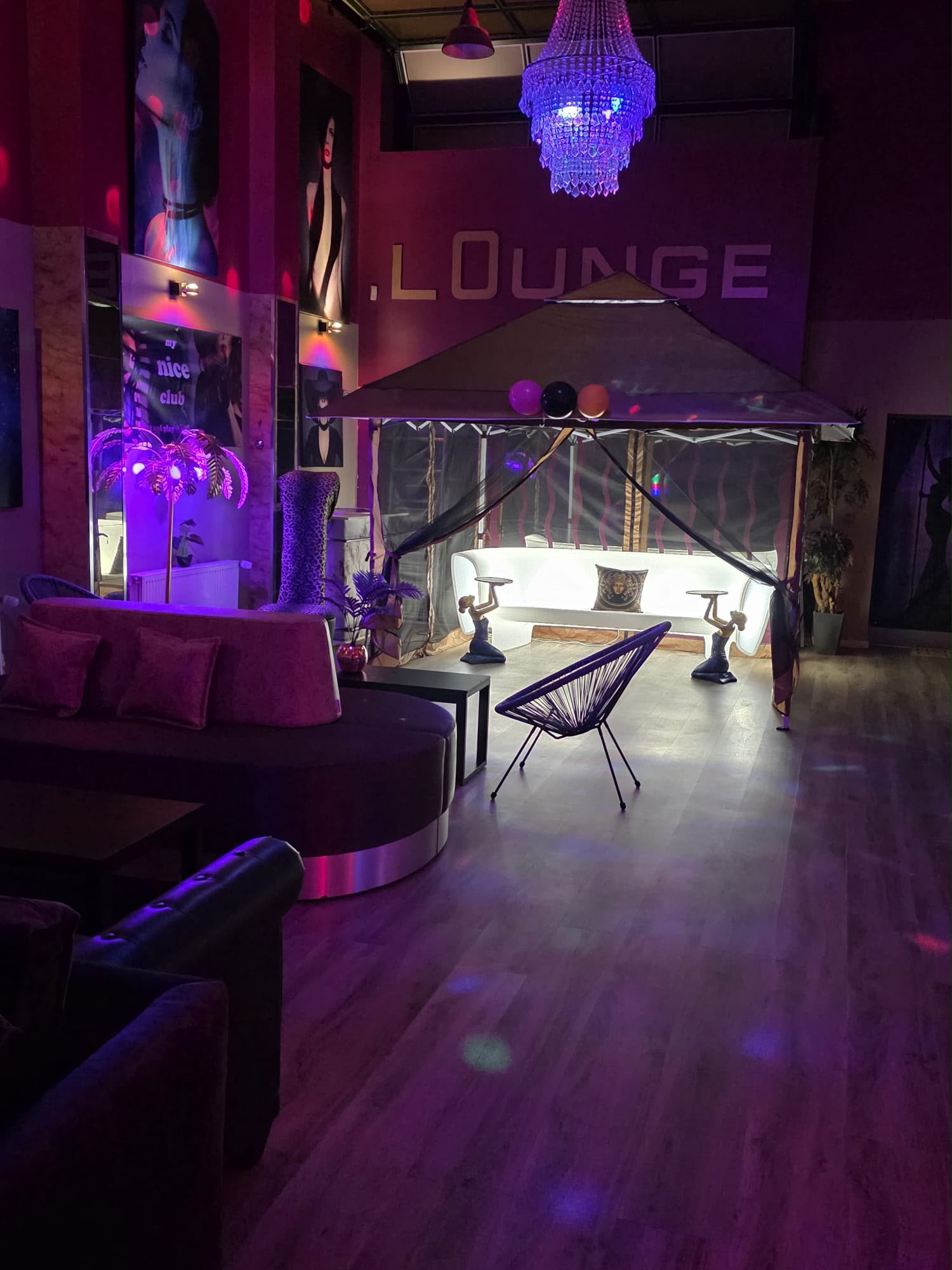 Lounge-Sitzbereich des Royal Love Club unter violettem Kronleuchter